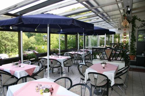 施里斯海姆鲁德威戈斯塔尔酒店的一间带桌椅和蓝伞的餐厅