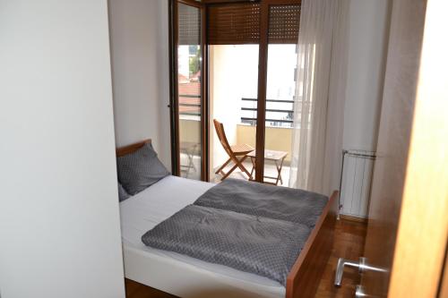 巴尼亚卢卡Apartment Lazarus Banja Luka的一间卧室设有一张床,享有阳台的景色