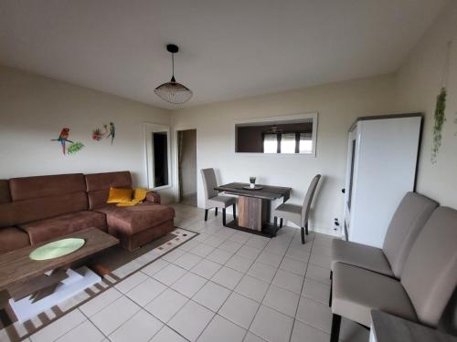 布里夫拉盖亚尔德DL LES 4 SAISONS - Meublé Tourisme 3 Etoiles的客厅配有沙发和桌子