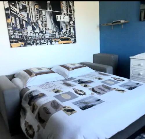 勒唐蓬Chambre privée dans maison的一间卧室,配有一张带照片的毯子的床