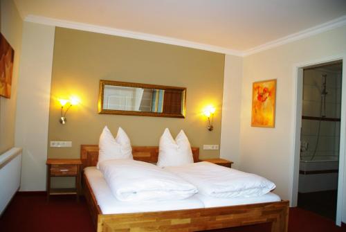 DohmaLandhotel Heidekrug的一间卧室配有带白色枕头的床