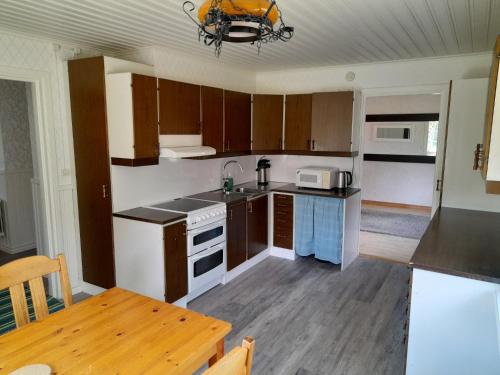 ÖverkalixHouse next door the Arctic Circle的一间带木制橱柜和桌子的厨房以及一间用餐室