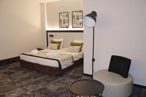 布鲁塞尔大广场弗洛里斯阿勒坎酒店的一间卧室配有一张床和一把椅子