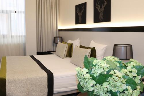 布鲁塞尔大广场弗洛里斯阿勒坎酒店的一间酒店客房,床上摆放着鲜花