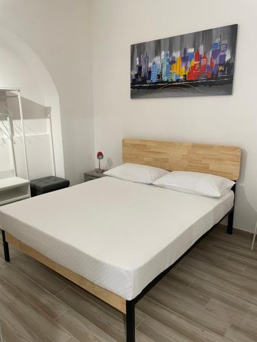 卡塔尼亚Corte Capuana的卧室内的一张床铺,配有白色床垫