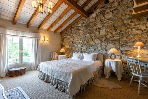 比达尔巴斯佑酒庄酒店的一间卧室设有一张床和石墙