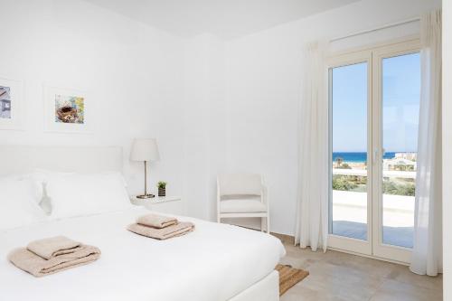 阿里克海滩Naxian Resort的一间白色的卧室,配有一张床,享有海景