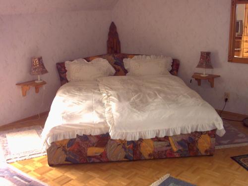 乌尔丁根-米赫尔霍芬Ferienwohnung Lucia Huber的卧室内的一张大床,配有两盏灯