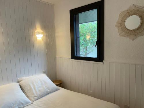 塞尼奥斯Appartement à Seignosse océan 2 chb et jardin的一间卧室设有一张床和一个窗口