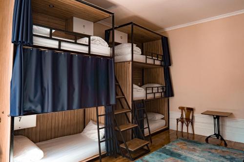 波尔图Rosalma Hostel的配有带蓝色窗帘的双层床的客房