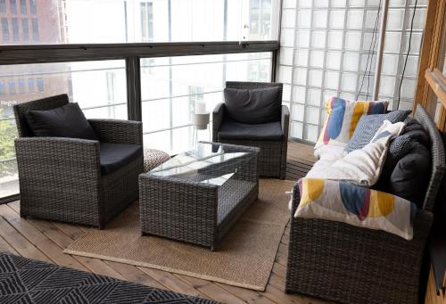 赫尔辛基2ndhomes Luxury 1BR Kamppi Center Apartment with Sauna and Big Terrace的客厅配有藤椅和桌子