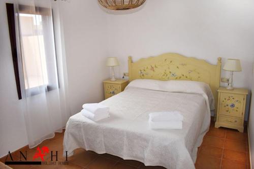拉奥利瓦Anahi Home Corralejo - Villa Cardon 12的一间卧室配有带2个床头柜和1扇窗户的床