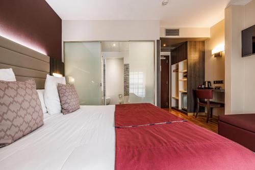巴塞罗那隆达雷赛布酒店的一间卧室配有一张带红色毯子的大床