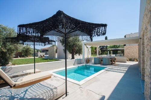 斯基亚索斯镇Utopia Eco Retreat的一个带遮阳伞的室外游泳池和一个游泳池