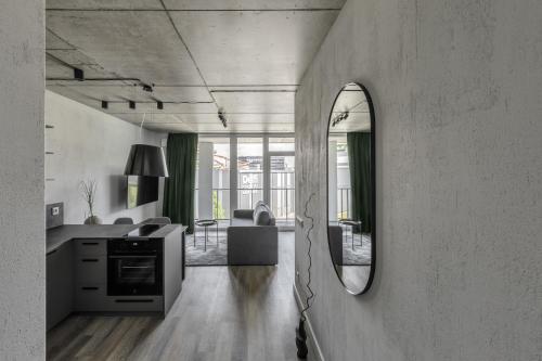维尔纽斯Urban Jungle Apartments by Reside Baltic的一间带镜子的客厅和一间厨房