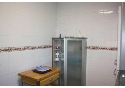 拉奥利瓦Anahi Homes Corralejo - Villa Drago 12的一间带冰箱和木桌的浴室