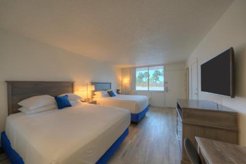 沃尔顿堡滩The Island Resort at Fort Walton Beach的酒店客房设有两张床和一台平面电视。