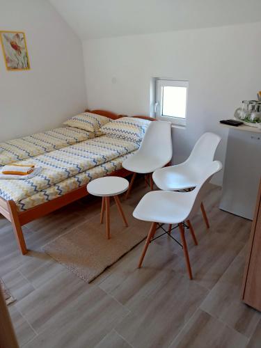 扎布利亚克Vila Danida的客房设有一张带白色椅子和一张桌子的床。