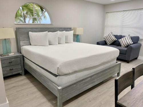 基拉戈Amoray Dive Resort的一间卧室配有一张大床和一张蓝色的沙发