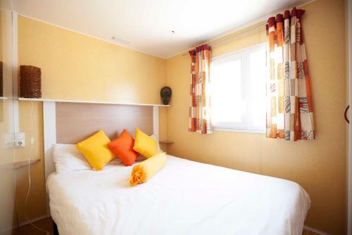 RoqueSunny Tiny House with Sea view的一间卧室配有白色的床和黄色及橙色枕头