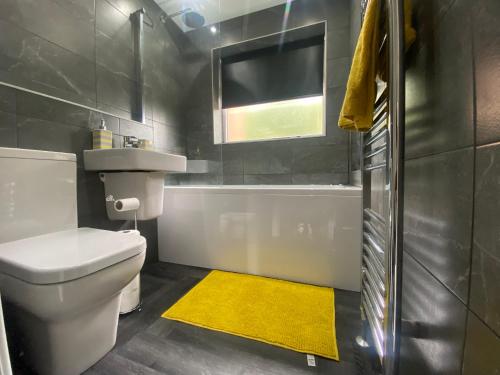 BeestonEntire Luxury Holiday Home leeds的浴室设有白色卫生间和黄色地毯。