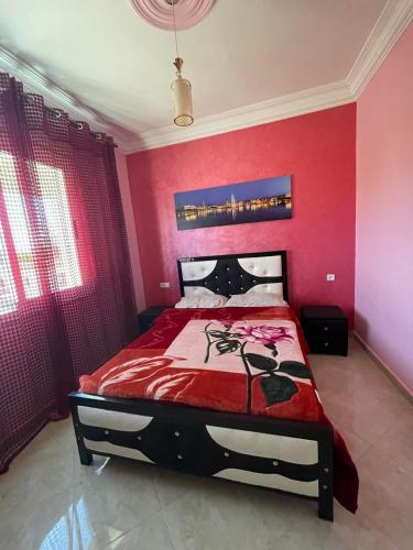 迈尔提勒appartement 10的卧室设有粉红色的墙壁和一张红色床单