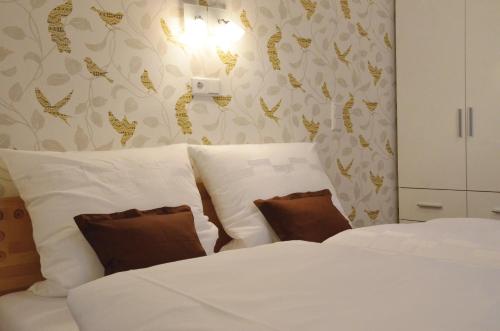 代特莫尔德Reisekultouren Apartments Detmold的一间卧室配有两张床,提供白色的床单和棕色的枕头