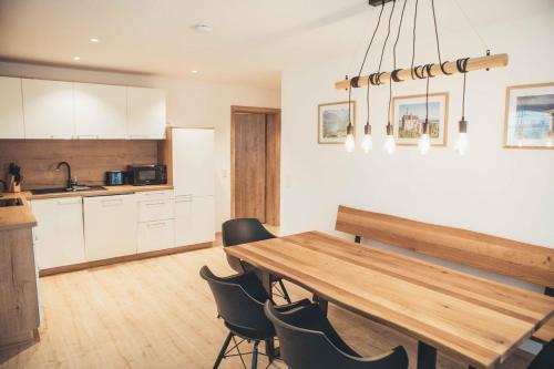 施万高Haus Schwangau的厨房以及带木桌和椅子的用餐室。