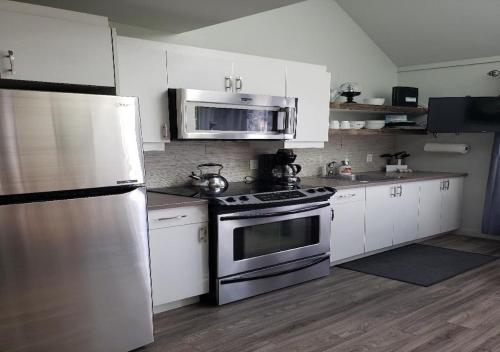 蒙特朗布朗perfect 'lil condo的厨房配有白色橱柜和不锈钢用具
