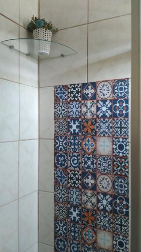 伊列乌斯Hospedaria Ilhéus 04的浴室设有瓷砖墙和一束瓷砖