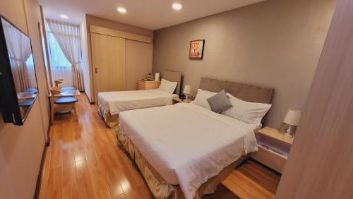 斯里巴加湾市Coconut Bay Lodge - Beribi的酒店客房设有两张床和窗户。
