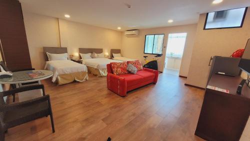斯里巴加湾市Coconut Bay Lodge - Beribi的酒店客房带两张床和一张红色沙发