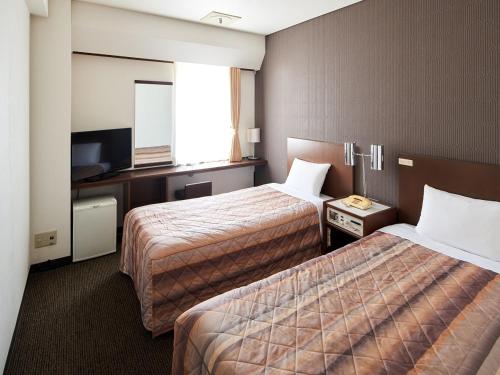 东京赤阪玛璐轩酒店的酒店客房设有两张床和电视。