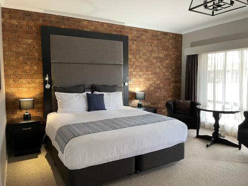 科罗瓦Federation Motel Resort - Corowa的一间卧室设有一张大床和砖墙