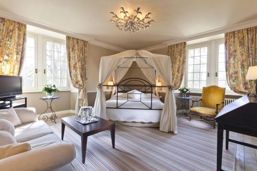 波特莱斯内吉米内城堡酒店的客厅配有床和沙发