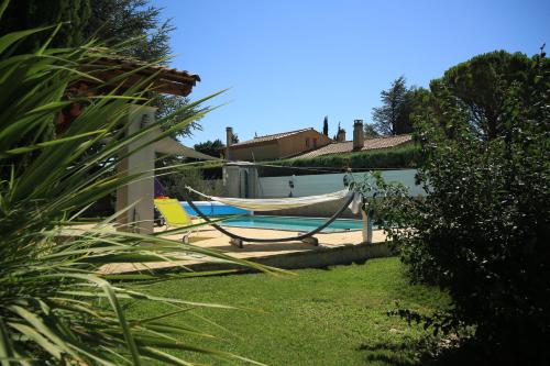艾居厄河畔卡马勒Chalet Mont Ventoux et Chalet VIP的房屋旁带吊床的游泳池