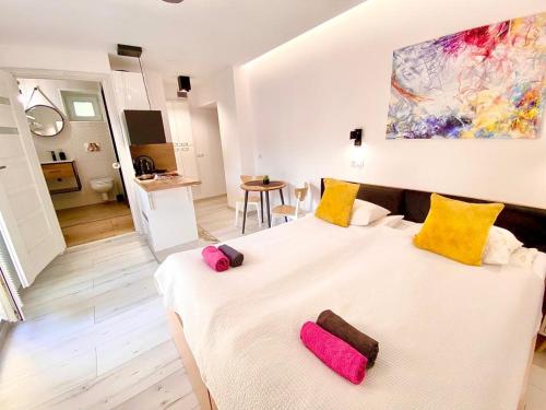 奥格罗杰涅茨SKALNY apartamenty, pokoje的卧室配有白色大床和黄色及粉红色枕头