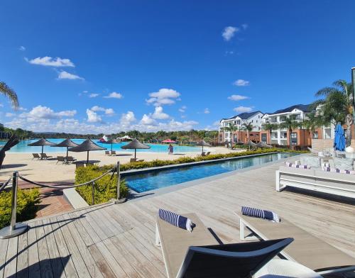 比勒陀利亚MINT Resorts The Blyde的度假村的游泳池,配有椅子和遮阳伞