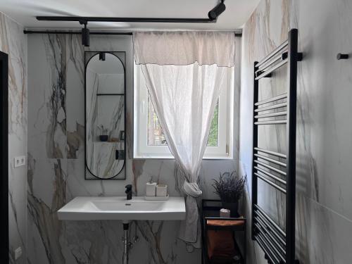 尤尔马拉Cozy beach house Jurmala III的一间带水槽和镜子的浴室以及窗户。