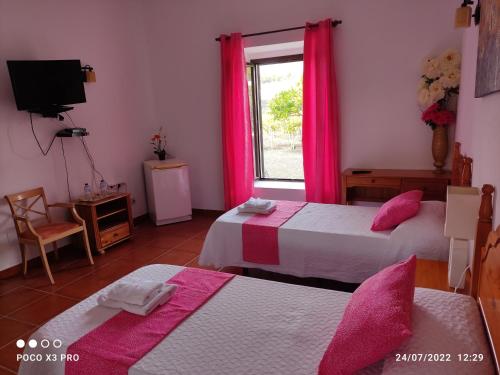 UgaNumero28,Casa Tilama的一间卧室设有两张床,窗户配有粉红色的窗帘