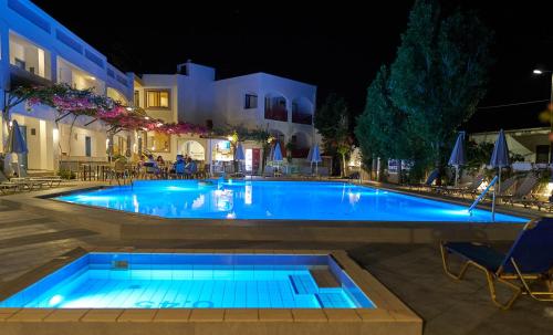 普拉坦斯Apollon Hotel Apartments的大楼前方设有蓝色灯光的大型游泳池