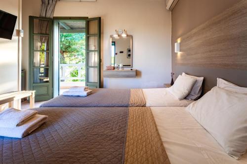 卡洛吉亚Kalogria Summer Retreats - Seimeio Strofilia, Sunny Vibes的一间卧室配有两张床和镜子
