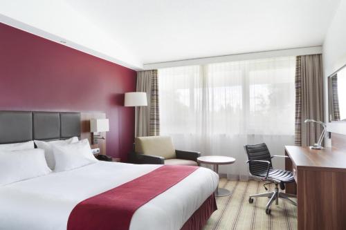 昂格洛里尔西方昂格洛智选假日酒店的配有一张床和一张书桌的酒店客房