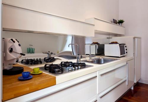 那不勒斯Elegant Apartment at Chiaia by Wonderful Italy的白色的厨房配有炉灶和水槽