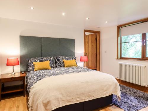 达特福德Willow Cottage的一间卧室配有一张带黄色枕头的大床