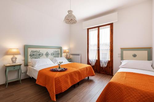 基安蒂格雷夫Casa Vacanze Alessandro 2的一间卧室配有两张床和一张带橙色床单的桌子。