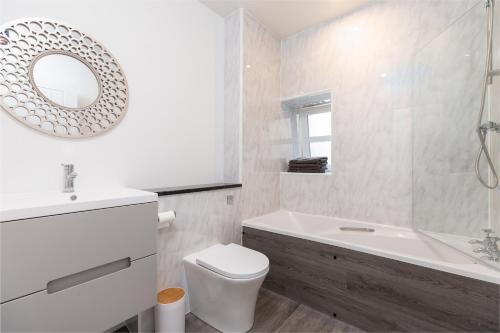 珀斯City centre 2 bedroom flat with on site parking的浴室配有盥洗池、卫生间和镜子。