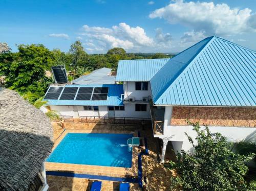 南威Boshowa Villas的享有带游泳池和蓝色屋顶的房屋的空中景致