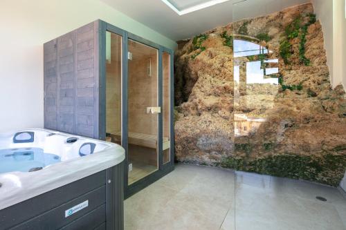 MoúndrosMoundros Luxury Villa & Spa的一间带水槽和岩石墙的浴室