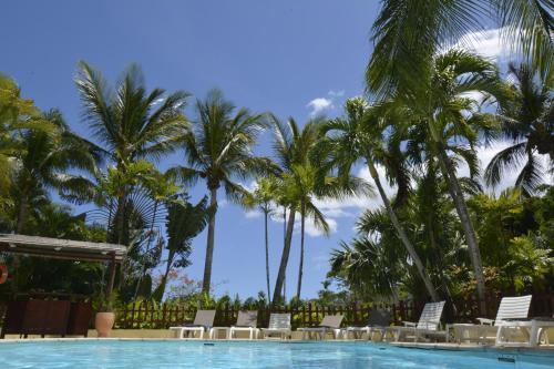 德赛Hotel - Résidence Habitation Grande Anse的一个带椅子的游泳池,棕榈树